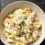 Creamy chicken tortellini Alfredo sauce with freshly grated parmesan cheese in a skillet