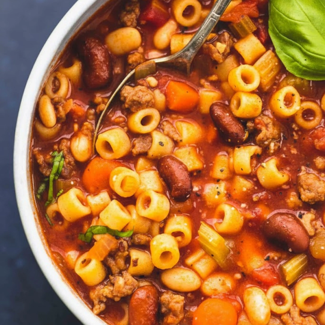 Hearty bowl of pasta e fagioli recipe served with fresh herbs
