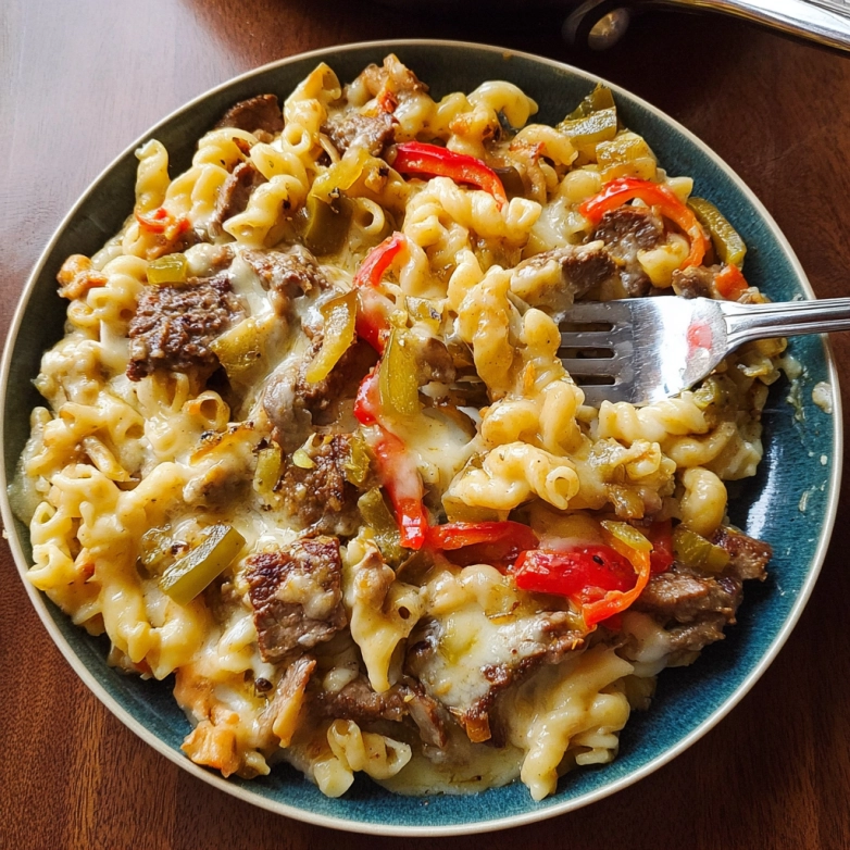 philly cheesesteak pasta recipe skillet close-up with peppers and steak