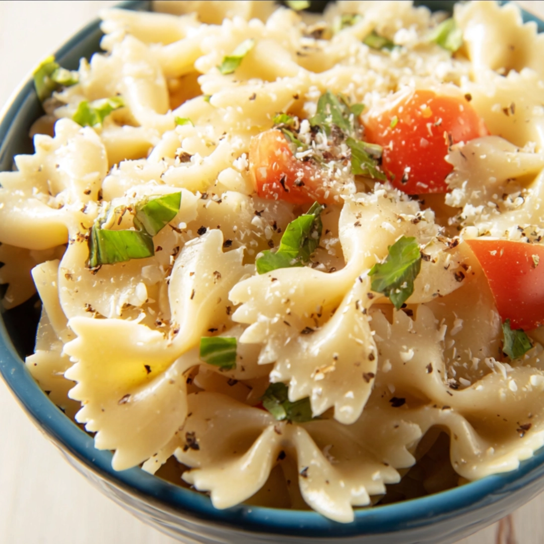 italian-bow-tie-pasta-salad-with-parmesan Bowl of Italian-style bow tie pasta salad with grated parmesan, basil, and cherry tomatoes