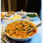 Hearty bowl of pasta e fagioli recipe served with fresh herbs