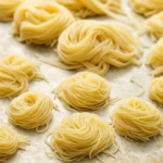 Fresh fettuccine from a gluten free pasta recipe on a floured board