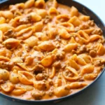 Large bowl of comforting, ultimate creamy beef and shells recipe garnished with parsley.