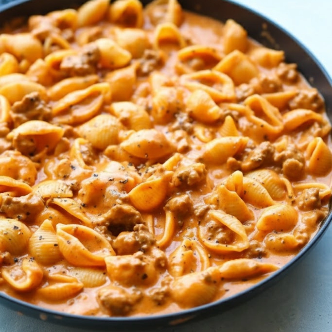 Large bowl of comforting, ultimate creamy beef and shells recipe garnished with parsley.