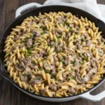 A bowl of creamy, savory Ground Beef Stroganoff served over egg noodles with fresh parsley. Title: The Best Gr