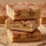 A close-up shot of baked, sliced chewy Cinnamon Sugar Blondies with a visible cinnamon swirl.