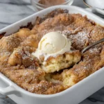 Warm Snickerdoodle Cobbler with a scoop of vanilla ice cream, featuring the golden cinnamon crust.