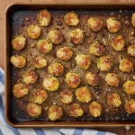 Platter of crispy oven-roasted Smashed Brussels Sprouts with melted Parmesan cheese.