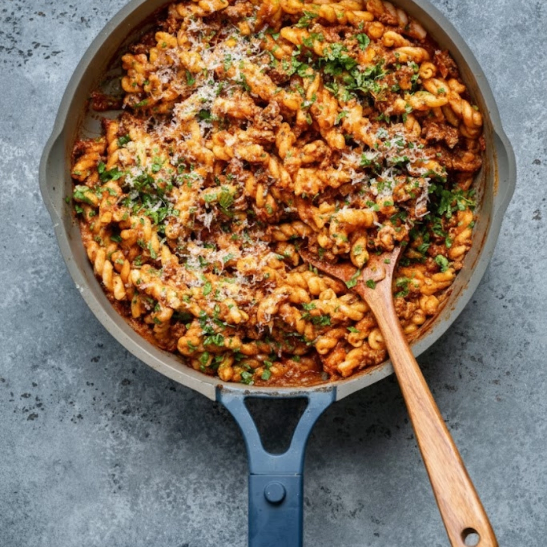 Creamy, hearty plate of One Pot Ground Beef Pasta Recipe garnished with basil and Parmesan.