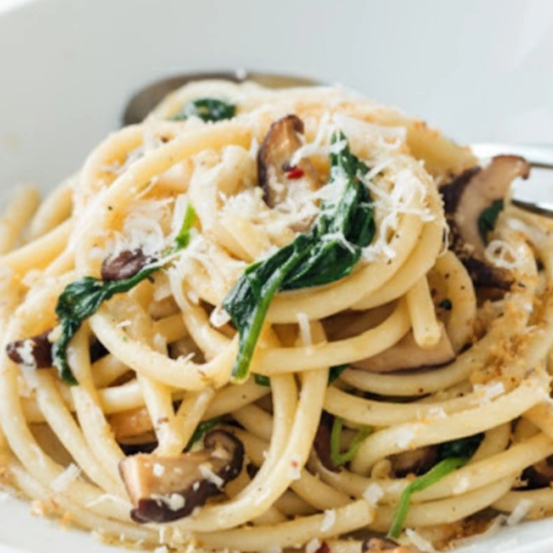 A large bowl of glossy, finished bucatini pasta recipe tossed in a bright garlic butter sauce with fresh parsley A large bowl of glossy, finished bucatini pasta recipe tossed in a bright garlic butter sauce with fresh parsley