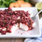 A beautifully plated Cranberry Jalapeño Cream Cheese Dip with crackers on a holiday platter.