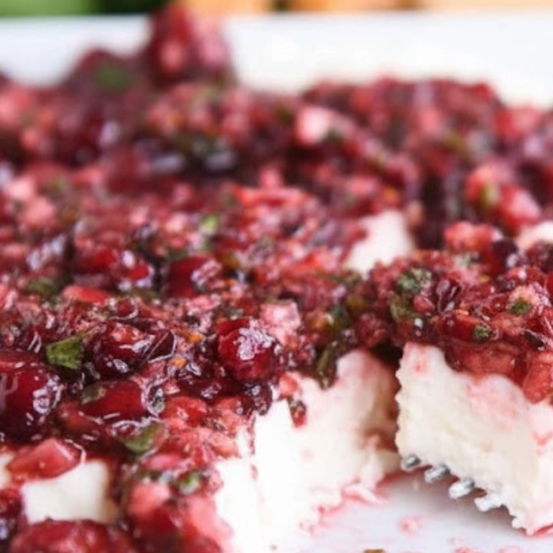 A beautifully plated Cranberry Jalapeño Cream Cheese Dip with crackers on a holiday platter.
