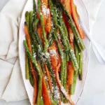 A close-up of a platter of perfectly seasoned and caramelized Roasted Asparagus and Carrots